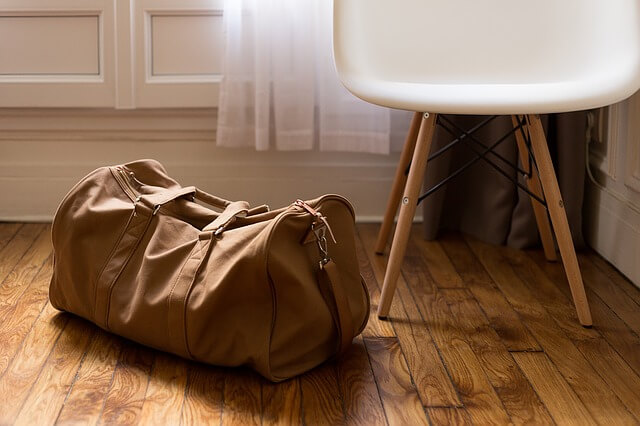 椅子の横に置かれた旅行バッグ